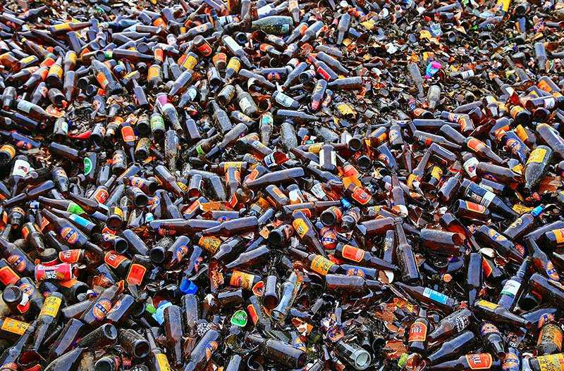 a large pile of empty brown glass beer bottles