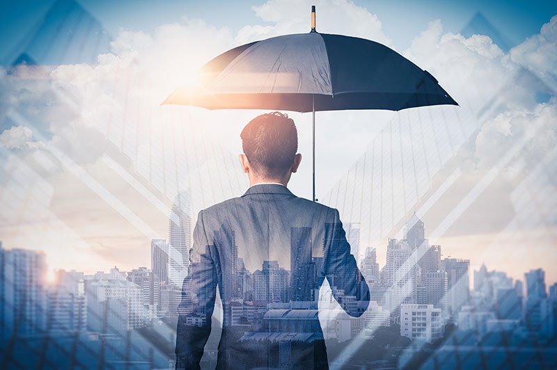 businessman holding umbrella for protection