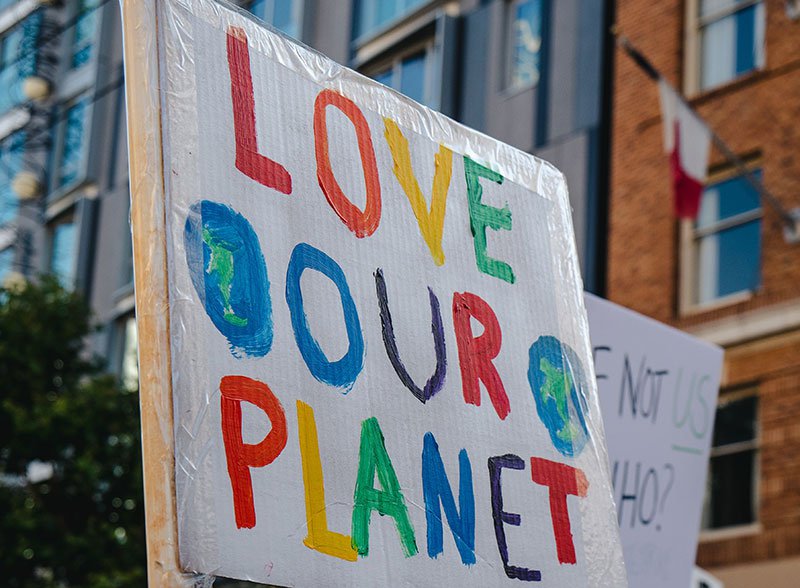 cardboard sign that says love our planet