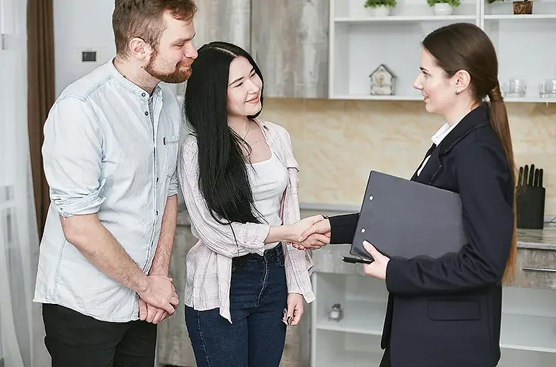 couple shaking hands with a business person