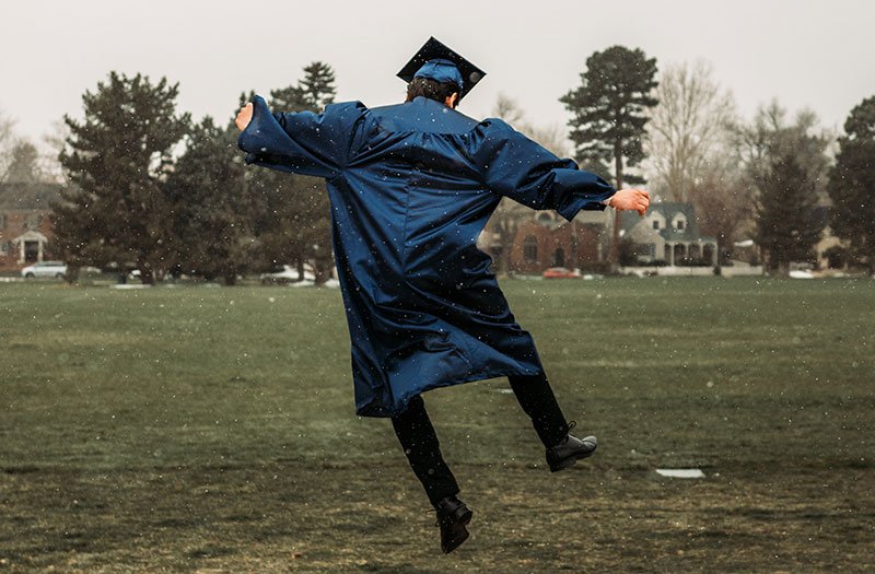 graduated student jumping in the air in happiness