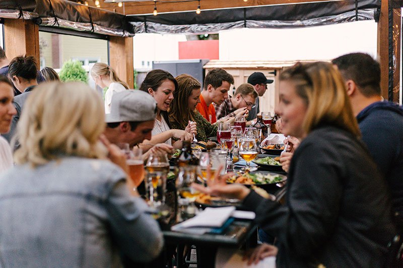 group-of-young-people-eating-outside-together