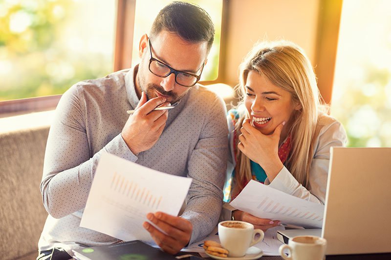 man and woman sitting side by side looking at documents