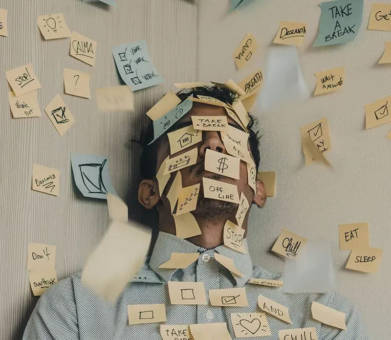 man lying on the ground covered in post it notes