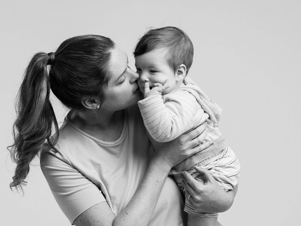 Portrait of MAS Member Katherine holding her child