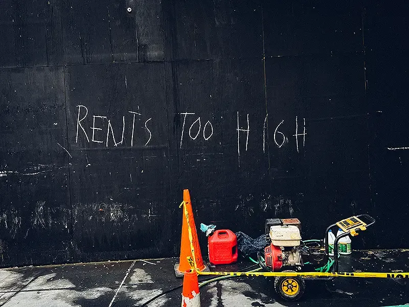 Run down wall with Rent&#39;s too High written on it