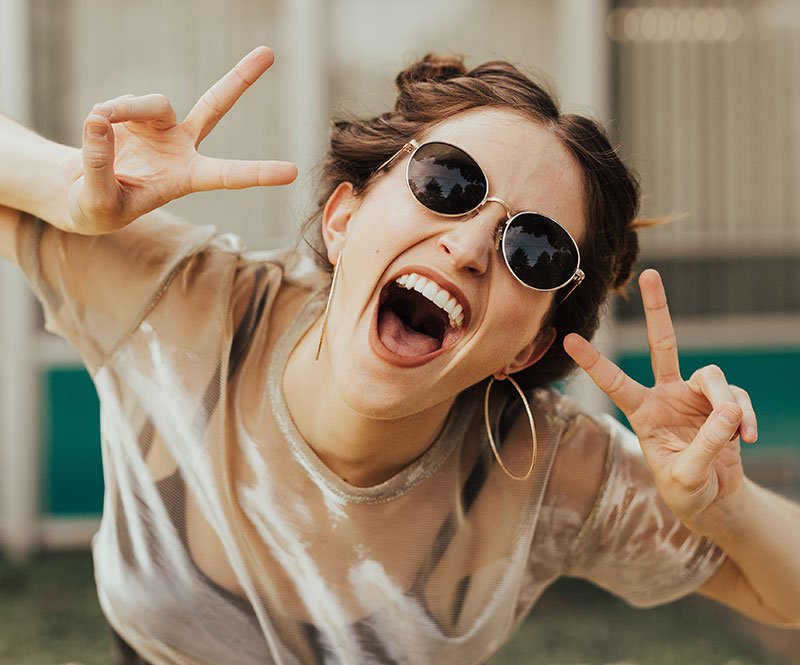 smiling girl giving the peace sign