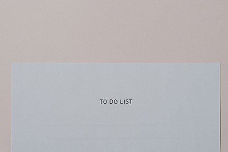 to do list typewritten on a blank piece of white paper against a pale pink backdrop