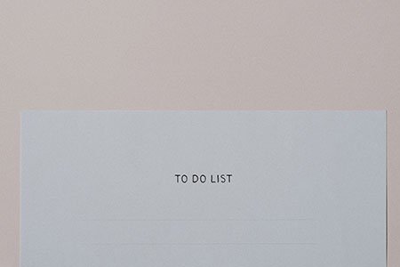 to do list typewritten on a blank piece of white paper against a pale pink backdrop