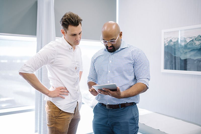 two men looking at ipad screen