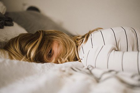 woman-lying-on-a-bed-dishevelled