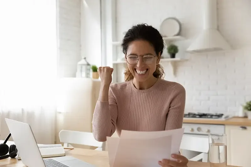woman excited looking at paper