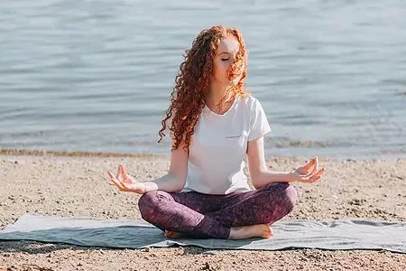 woman meditating on a beach - listing