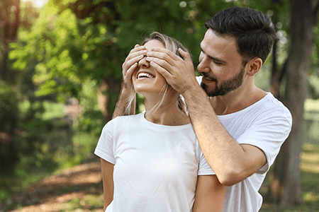 young-couple-dressed-in-white-playing-blindfolded-with-happy-faces-laughing