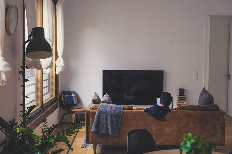 young-woman-sitting-on-couch-using-laptop